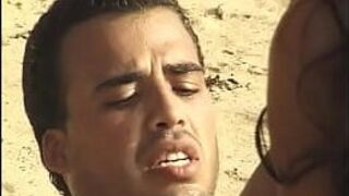 Hot babe works two dicks on the sand - porn video